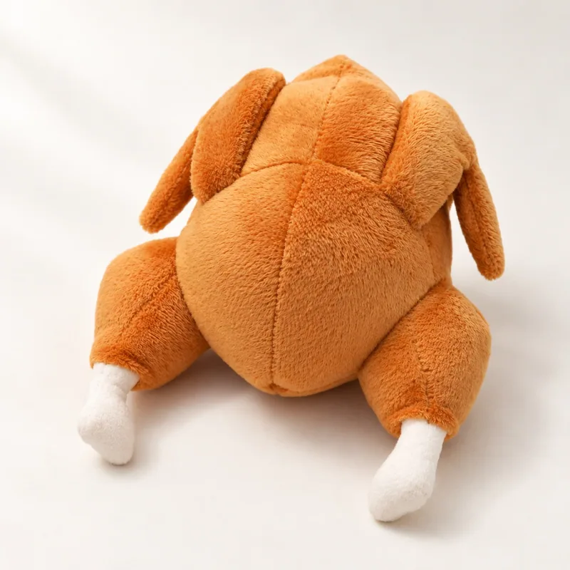 One caramel-orange roast-turkey-shaped plush dog toy with two cream fabric ends