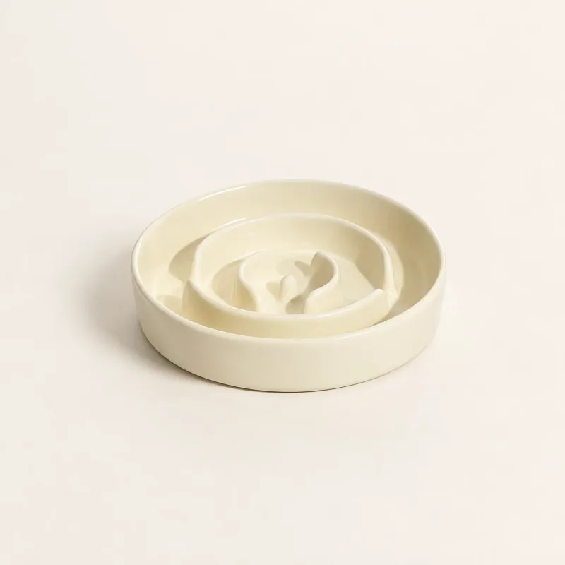 Beige ceramic maze bowl with its curved internal channels, shown empty without a stand.