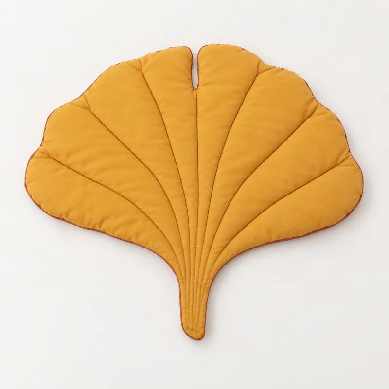 Yellow quilted ginkgo-leaf mat with terracotta edging.