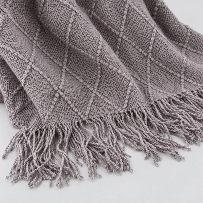 Closer view of the gray diamond knit and long fringe