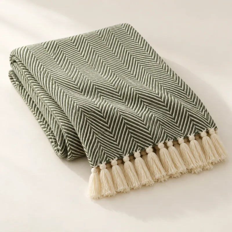 Folded green and ivory herringbone throw with ivory fringe