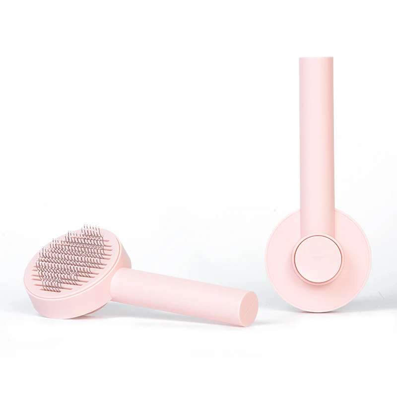 Two views of a pink grooming brush showing the round pin head and rear cleaning button.