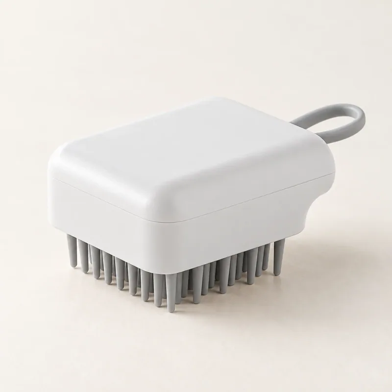 White Palm Bath Brush with gray flexible bristles and a gray hanging loop on a pale tabletop.