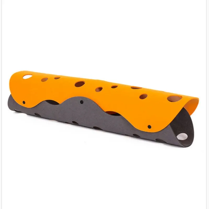 Orange and charcoal felt panels snapped together into a long tunnel with circular cutouts.