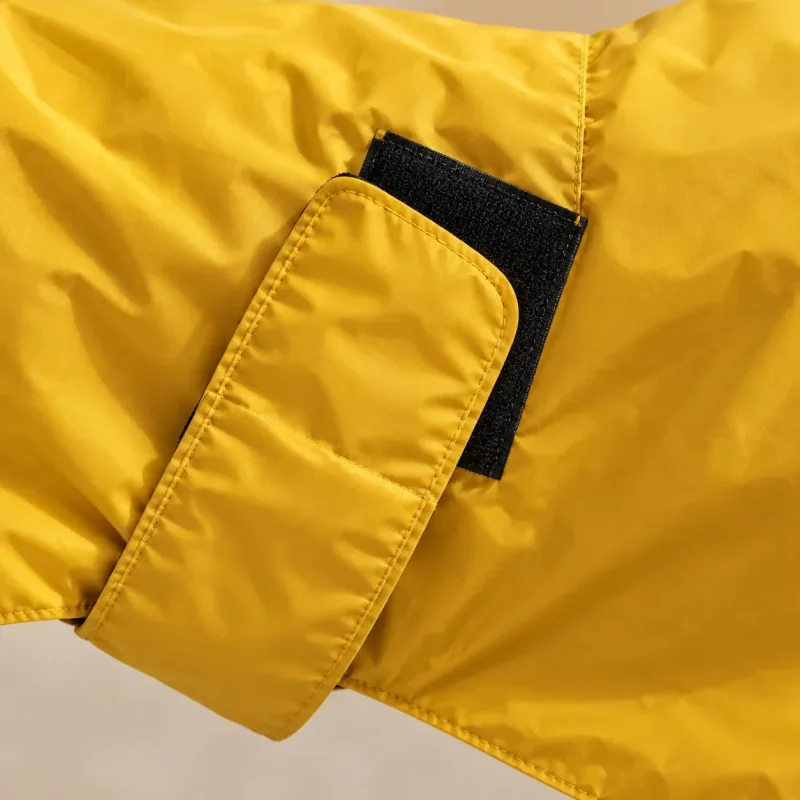Close view of the yellow rain shell and black side fastening patch.
