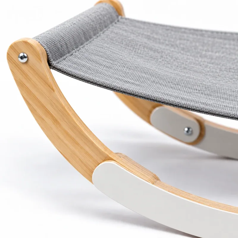 Close view of the gray fabric sling attached to the curved wooden hammock frame.