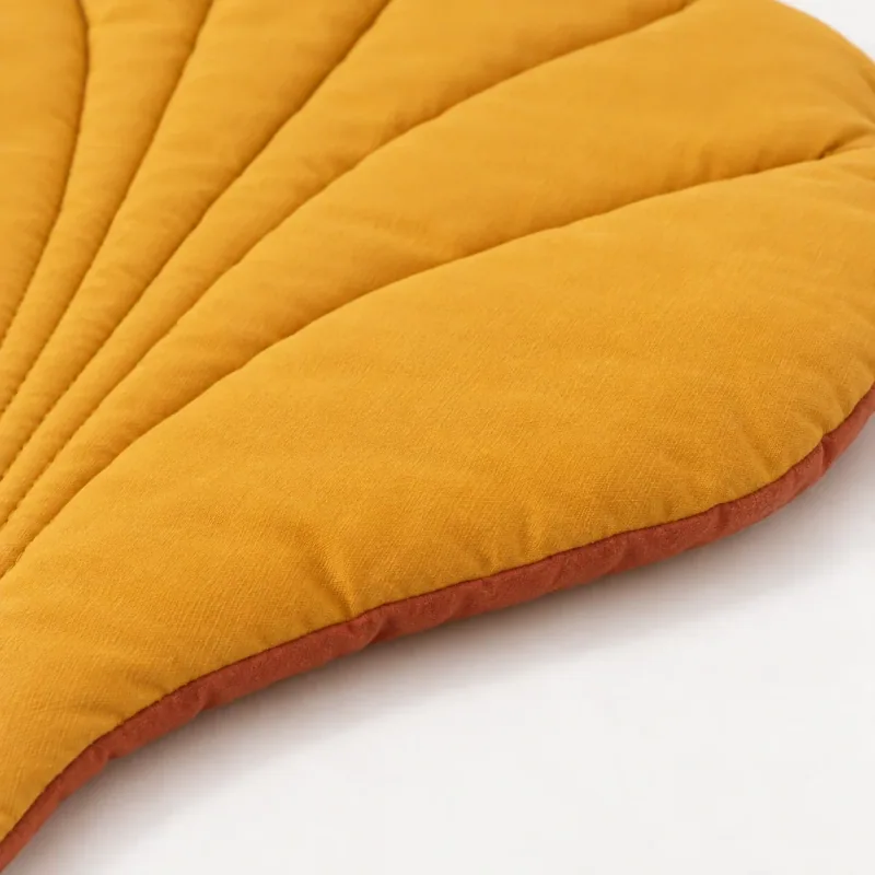 Close view of the yellow quilted leaf mat with terracotta edging.